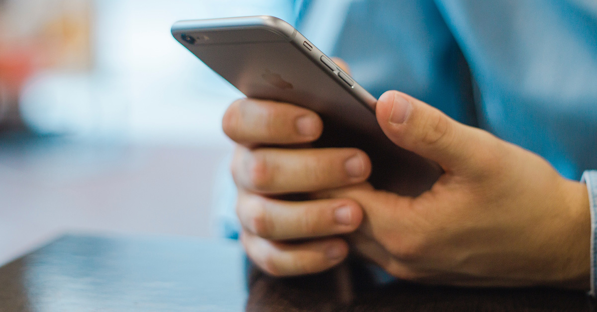 Man's hands holding a mobile phone